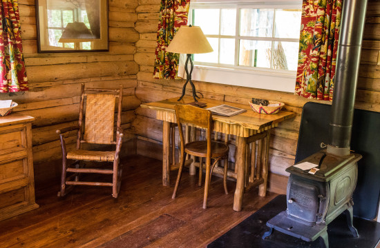 Wood-fired stove and desk in the bedroom at Dining Cabin 6 | Dubois Wyoming Lodging | CM Ranch