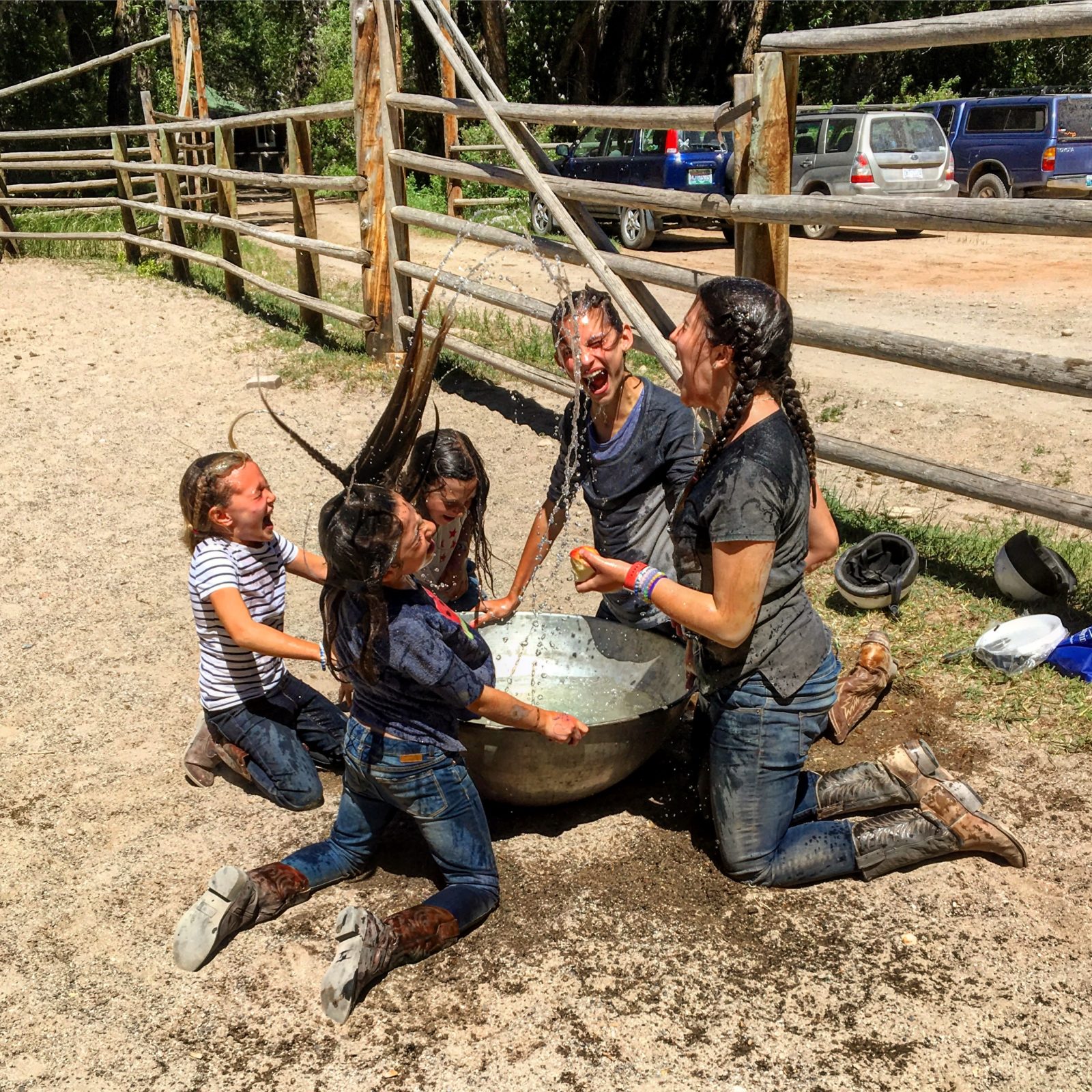 Kids cool off with water inside the horse pen at CM Ranch in Dubois, WY | Dude Ranch Wyoming Family