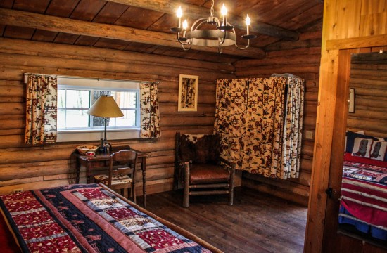 Bed, dresser, tables and chairs in Dining Cabin | Wyoming Guest Ranches | CM Ranch