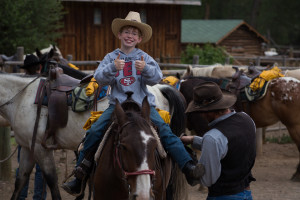 A boy on horseback gives a double thumbs-up at CM Ranch in Dubois, WY | Wyoming dude ranch