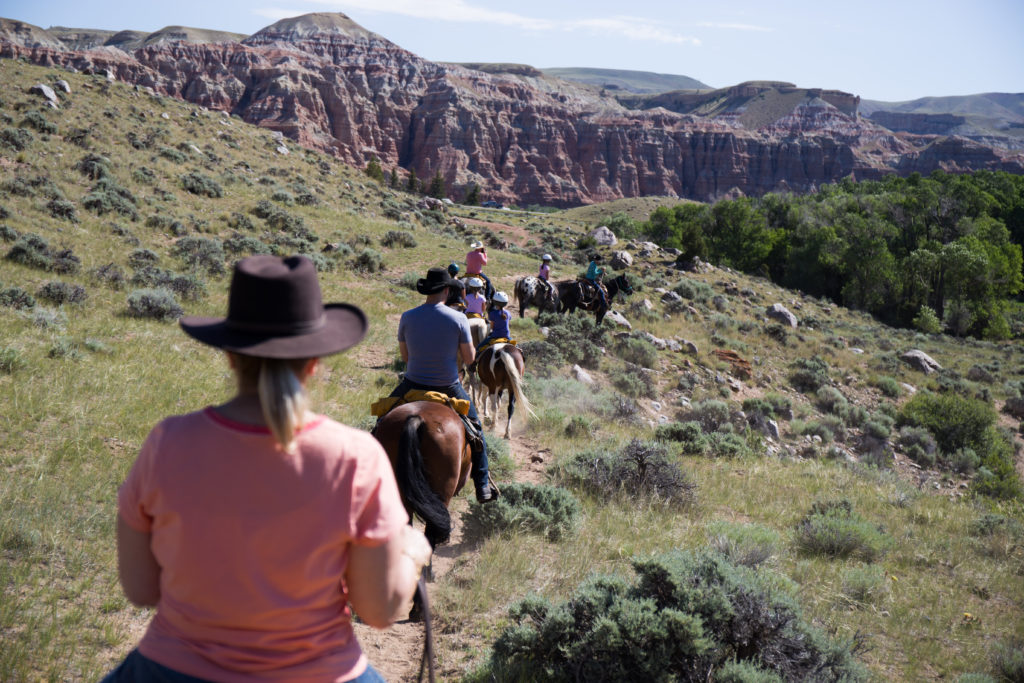 A groups of guests on horseback out for a trail ride in the mountains near CM Ranch in Dubois, WY | Horseback Riding Jackson Hole