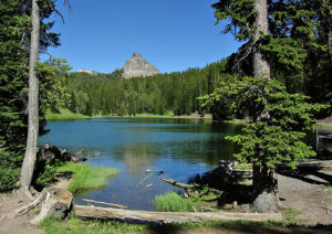 A mountain top peeks above the treeline at an alpine lake in Wyoming