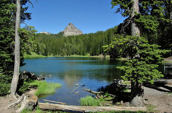 A mountain top peeks above the treeline at an alpine lake in Wyoming