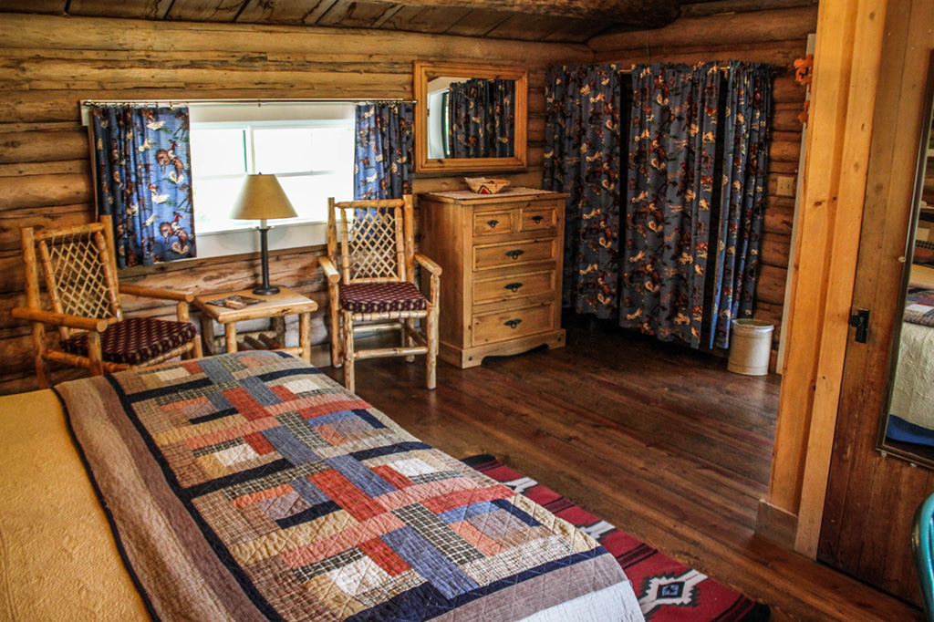 Bed, table and chairs, dresser in Dining Cabin 2 | Best Dude Ranches in Wyoming | CM Ranch