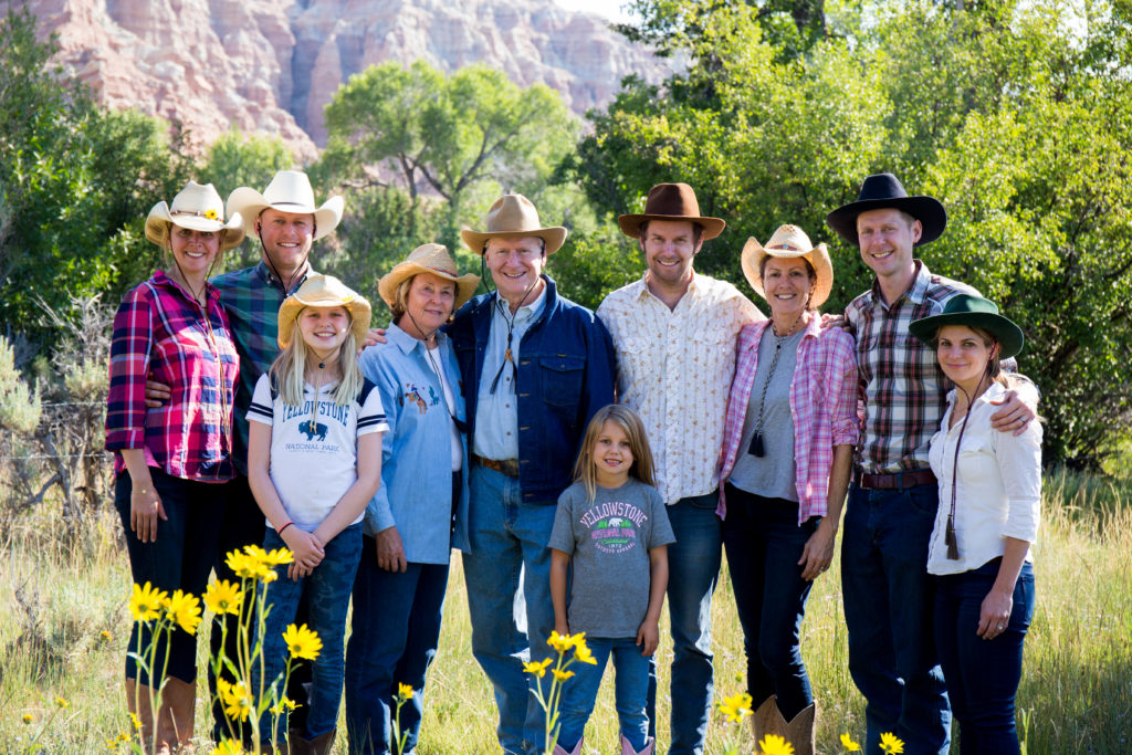 A family poses for a portrait in a field at CM Ranch in Dubois, WY | affordable family dude ranch vacations